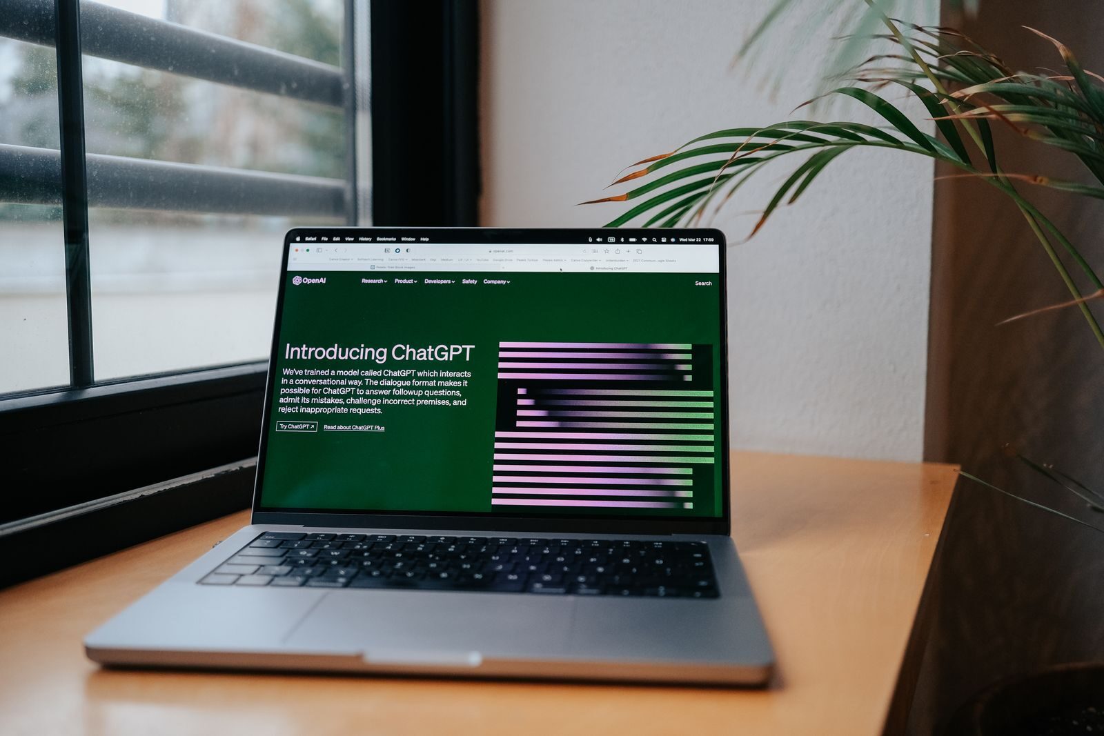 Laptop z otwartą stroną ChatGPT na biurku przy oknie