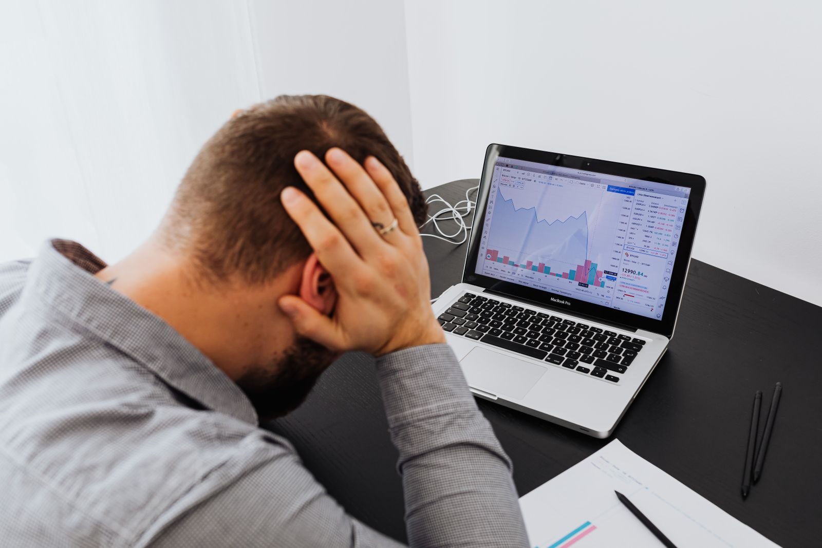 Mężczyzna łapie się za głowę przed laptopem po spadku pozycji w Google