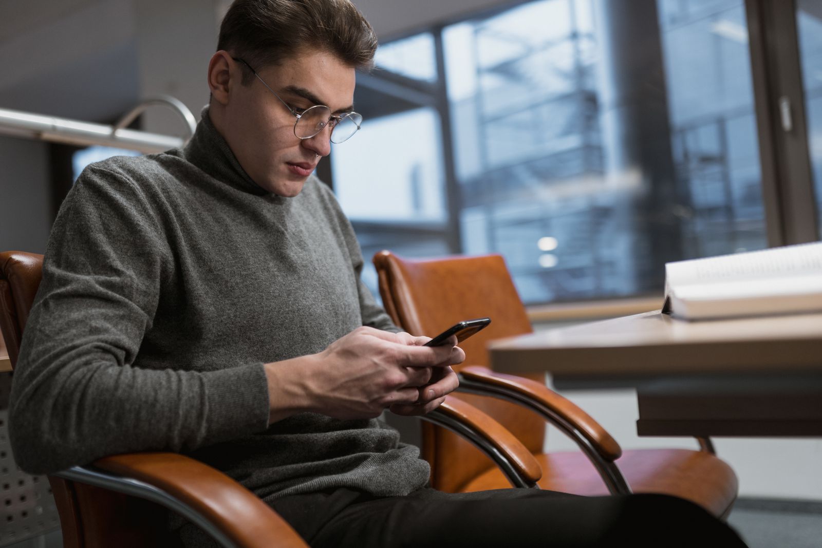 Mężczyzna sprawdza na smartfonie wygląd serwisu przed zamówieniem publikacji